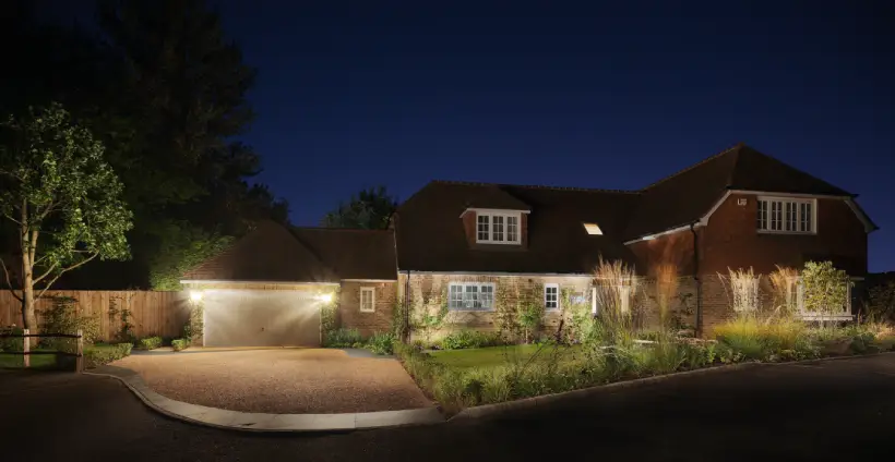 front of house with a gravel driveway and outdoor lighting